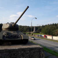 stredný tank T34-85 obci Vyšný Komárnik v okrese Svidník, v pozadí Pamätník 1. ČSAZ (september 2017) 