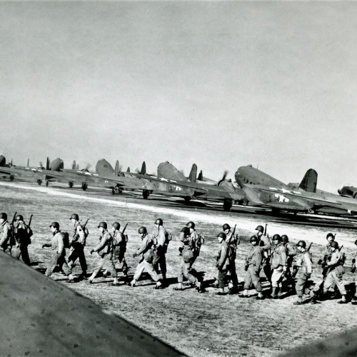 Americkí výsadkári nastupujú v Anglicku do pripravených dopravných lietadiel.